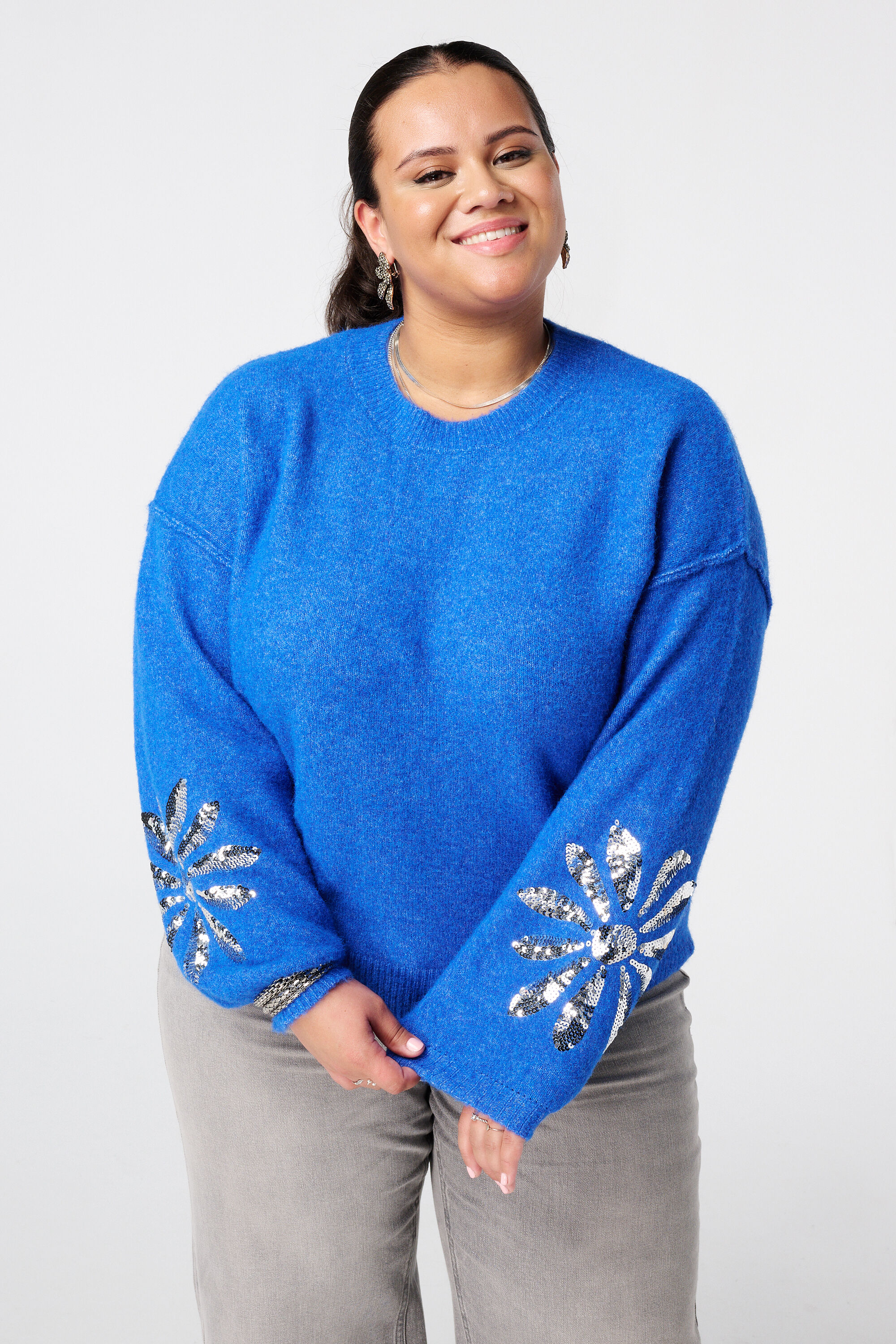 Gebreide trui met pailletten op de mouwen